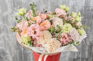 Kadının elinde küçük, güzel bir buket karışık çiçek. Çiçek dükkanı konsepti. Taze kesilmiş güzel bir buket. Çiçek teslimatı. Yüksek kalite fotoğraf