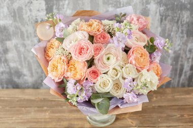 Kadının elinde küçük, güzel bir buket karışık çiçek. Çiçek dükkanı konsepti. Taze kesilmiş güzel bir buket. Çiçek teslimatı. Yüksek kalite fotoğraf