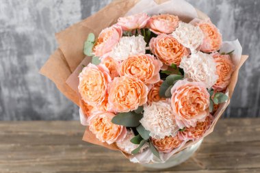 Kadının elinde küçük, güzel bir buket karışık çiçek. Çiçek dükkanı konsepti. Taze kesilmiş güzel bir buket. Çiçek teslimatı. Yüksek kalite fotoğraf