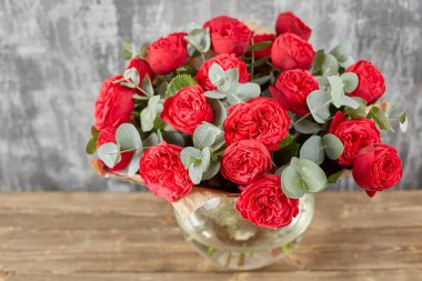 Kadının elinde küçük, güzel bir buket karışık çiçek. Çiçek dükkanı konsepti. Taze kesilmiş güzel bir buket. Çiçek teslimatı. Yüksek kalite fotoğraf