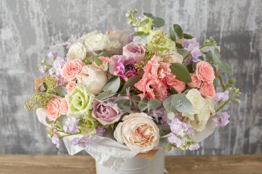 Kadının elinde küçük, güzel bir buket karışık çiçek. Çiçek dükkanı konsepti. Taze kesilmiş güzel bir buket. Çiçek teslimatı. Yüksek kalite fotoğraf