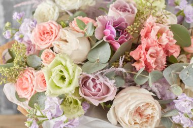 Kadının elinde küçük, güzel bir buket karışık çiçek. Çiçek dükkanı konsepti. Taze kesilmiş güzel bir buket. Çiçek teslimatı. Yüksek kalite fotoğraf