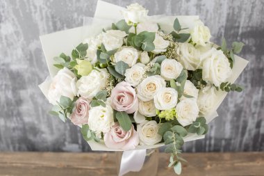 Beyaz, güzel bir buket karışık çiçek kadının elinde. Çiçek dükkanı konsepti. Taze kesilmiş güzel bir buket. Çiçek teslimatı. Yüksek kalite fotoğraf