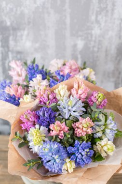 Kadının elinde küçük, güzel bir buket karışık çiçek. Çiçek dükkanı konsepti. Taze kesilmiş güzel bir buket. Çiçek teslimatı. Yüksek kalite fotoğraf