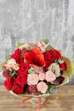 Kadının elinde küçük, güzel bir buket karışık çiçek. Çiçek dükkanı konsepti. Taze kesilmiş güzel bir buket. Çiçek teslimatı. Yüksek kalite fotoğraf