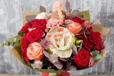 Kadının elinde küçük, güzel bir buket karışık çiçek. Çiçek dükkanı konsepti. Taze kesilmiş güzel bir buket. Çiçek teslimatı. Yüksek kalite fotoğraf