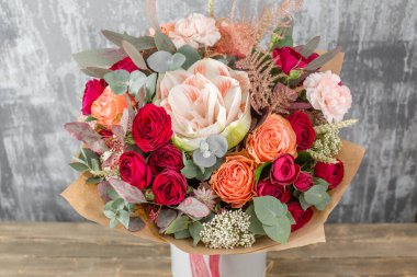 Kadının elinde küçük, güzel bir buket karışık çiçek. Çiçek dükkanı konsepti. Taze kesilmiş güzel bir buket. Çiçek teslimatı. Yüksek kalite fotoğraf