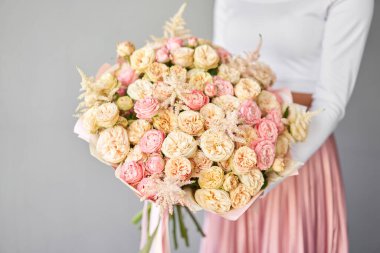 Kadının elinde küçük, güzel bir buket karışık çiçek. Çiçek dükkanı konsepti. Taze kesilmiş güzel bir buket. Çiçek teslimatı. Yüksek kalite fotoğraf