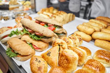 Taze sandviç, turta ve pizza bir kafe, açık büfe veya self-servis kafe vitrininde tercih edilebilir. Jambonlu ve peynirli kruvasan. Kafedeki rafta sıcak hamur işleri var. Çörekler dükkanda. Yüksek