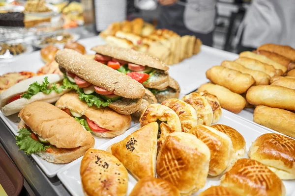 Taze sandviç, turta ve pizza bir kafe, açık büfe veya self-servis kafe vitrininde tercih edilebilir. Jambonlu ve peynirli kruvasan. Kafedeki rafta sıcak hamur işleri var. Çörekler dükkanda. Yüksek