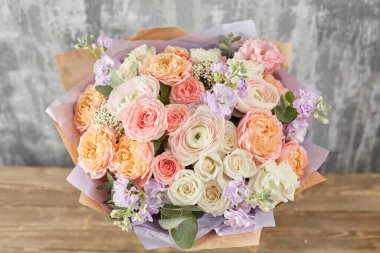 Kadının elinde küçük, güzel bir buket karışık çiçek. Çiçek dükkanı konsepti. Taze kesilmiş güzel bir buket. Çiçek teslimatı. Yüksek kalite fotoğraf