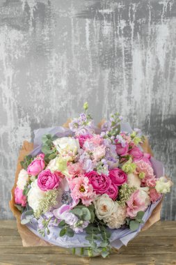 Kadının elinde küçük, güzel bir buket karışık çiçek. Çiçek dükkanı konsepti. Taze kesilmiş güzel bir buket. Çiçek teslimatı. Yüksek kalite fotoğraf