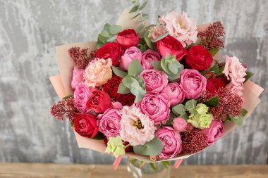 Kadının elinde küçük, güzel bir buket karışık çiçek. Çiçek dükkanı konsepti. Taze kesilmiş güzel bir buket. Çiçek teslimatı. Yüksek kalite fotoğraf