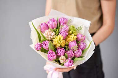 Laleler kadının elinde. Elinde bir buket kırmızı lale. Bir demet taze bahar çiçeği. Yüksek kalite fotoğraf