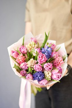 Güneşli bir bahar sabahı. Genç, mutlu bir kadın elinde bir sürü sümbül ve lale tutuyor. Gülümseyen bir kıza hediye. Çiçek buketi. Yüksek kalite fotoğraf