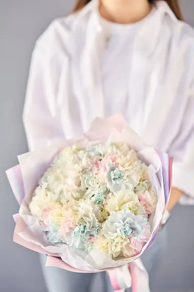 Beautiful Rainbow mono bouquet of flowers in woman hand. Floral shop concept . Beautiful fresh cut bouquet. Flowers delivery. Flowers delivery.