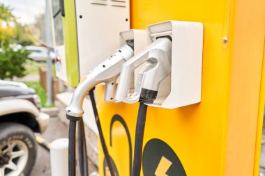 Elektrikli araba şarjı için güç kaynağı. Elektrikli araba şarj istasyonu. Şarj olan bir elektrikli arabaya takılan güç kaynağını kapatın. Yüksek kalite fotoğraf. 