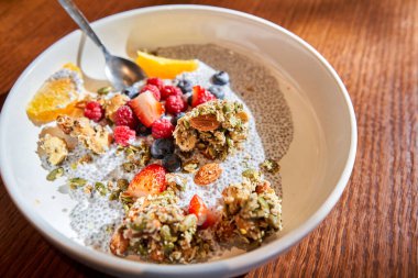 Ev yapımı hindistan cevizi taneli puding, fıstık ezmesi ve gri kasede böğürtlen. Sağlıklı bitki temelli diyet, detoks, yaz tarifi. Lokantada kahvaltı. Yüksek kalite fotoğraf