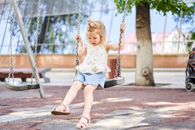 Net tırmanma ve okul bahçesinde Bahçesi, trambolin üzerinde atlama oynayan etkin küçük çocuk. Çocuklar oynamak ve açık havada güneşli yaz gününde tırmanmak. Okul öncesi spor Merkezi'nde yuva salıncak üzerinde sevimli kız