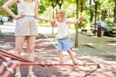 Net tırmanma ve okul bahçesinde Bahçesi, trambolin üzerinde atlama oynayan etkin küçük çocuk. Çocuklar oynamak ve açık havada güneşli yaz gününde tırmanmak. Okul öncesi spor Merkezi'nde yuva salıncak üzerinde sevimli kız