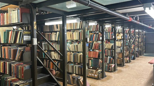 Modern library with floor-to-ceiling bookshelves filled with books.