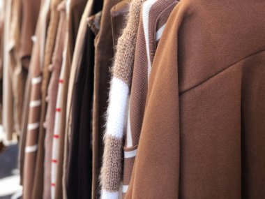 Brown beige clothes hanging in a thrift store
