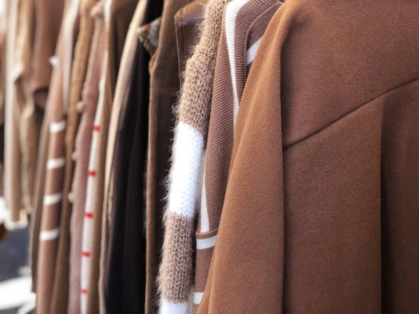 Brown beige clothes hanging in a thrift store