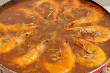 Altın yağda kızartılmış karidesin geleneksel İspanyol paella 'sındaki canlı lezzet karışımına dönüşmesi gibi deneysel mutfak uyumu her lokmayı zevkli bir lezzetle zenginleştirir.