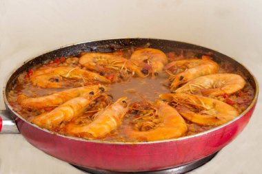 Altın yağda kızartılmış karidesin geleneksel İspanyol paella 'sındaki canlı lezzet karışımına dönüşmesi gibi deneysel mutfak uyumu her lokmayı zevkli bir lezzetle zenginleştirir.