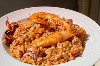 İspanya 'nın ikonik lezzetlerine bir tabak paella ile dalın, canlı deniz ürünleri, pirinç ve aromatik baharatlar sergilensin..