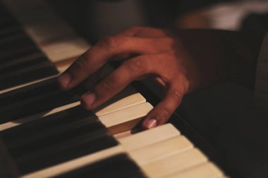 Geniş bir açıklıkla yakalanmış, eski bir beyaz tonk piyanosunu çalan siyahi bir adamın büyüleyici görüntüsü. Bu sahne yaratıcılığı ve ilhamı temsil eder.