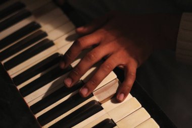 Geniş bir açıklıkla yakalanmış, eski bir beyaz tonk piyanosunu çalan siyahi bir adamın büyüleyici görüntüsü. Bu sahne yaratıcılığı ve ilhamı temsil eder.