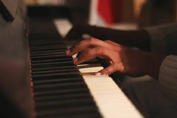 stock image A captivating image of a black man's hands playing an old honky tonk piano, captured with a wide aperture. This scene embodies creativity and inspiration