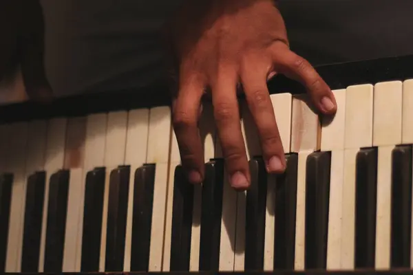 Stock image A captivating image of a black man's hands playing an old honky tonk piano, captured with a wide aperture. This scene embodies creativity and inspiration