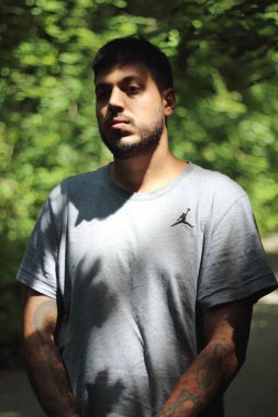 Zürih şehrinde güneşli bir günün tadını çıkaran, spor elbiseli dövmeli genç bir adamın canlı görüntüsü. Kentsel yaşam tarzı, fitness ve modern kültürle ilgili konular için mükemmel..