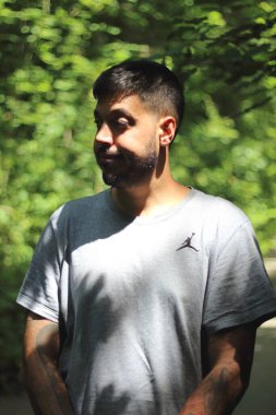 Zürih şehrinde güneşli bir günün tadını çıkaran, spor elbiseli dövmeli genç bir adamın canlı görüntüsü. Kentsel yaşam tarzı, fitness ve modern kültürle ilgili konular için mükemmel..