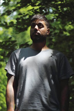 Zürih şehrinde güneşli bir günün tadını çıkaran, spor elbiseli dövmeli genç bir adamın canlı görüntüsü. Kentsel yaşam tarzı, fitness ve modern kültürle ilgili konular için mükemmel..