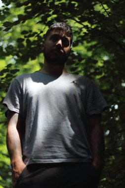 Zürih şehrinde güneşli bir günün tadını çıkaran, spor elbiseli dövmeli genç bir adamın canlı görüntüsü. Kentsel yaşam tarzı, fitness ve modern kültürle ilgili konular için mükemmel..