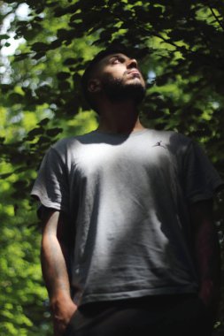 Zürih şehrinde güneşli bir günün tadını çıkaran, spor elbiseli dövmeli genç bir adamın canlı görüntüsü. Kentsel yaşam tarzı, fitness ve modern kültürle ilgili konular için mükemmel..