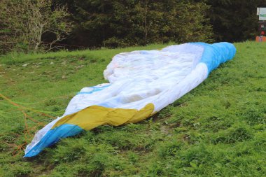 Kalkış için hazırlıklar yapılırken yerde bir paraglider yatıyor. Olay yeri, titiz bir hazırlık sürecini ve maceralı bir uçuş beklentisini yakalıyor..