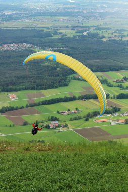Güney Bavyera 'daki bir dağdan havalandıktan hemen sonra dişi bir paraglider zarif bir şekilde gökyüzüne yükselir. Sahne, uçmanın coşkusunu ve özgürlüğünü yakalıyor..