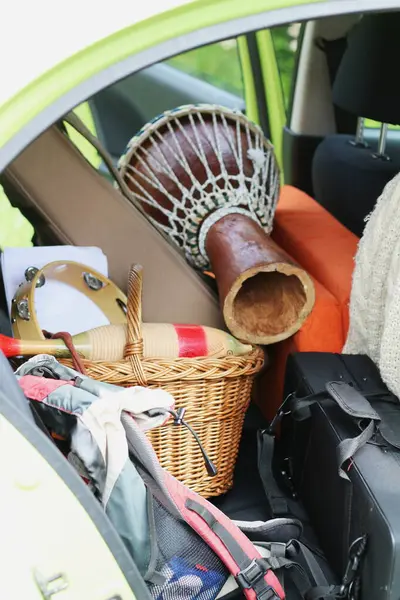 stock image The back of a car is packed with musical instruments for a tour, including a djembe, saxophone, and various percussion instruments. The scene captures the excitement of a musicians journey.