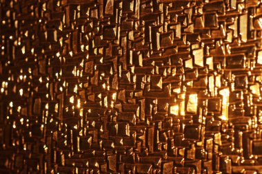 Gün batımının sıcak, altın tonlarını yansıtan parlak bir cam. Soyut doku ışık ve yüzeyin etkileşimini vurgular, büyüleyici ve ışıltılı bir görsel etki yaratır..