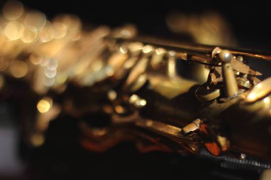 Paslı, antika bir saksafonun soyut bir makro görüntüsü, dokulu yüzeyine odaklanmış ve yıpranmış bir zarafet.