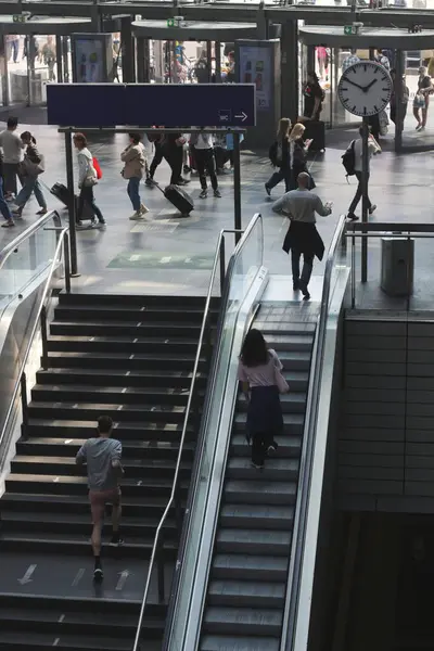 Dinamik çekimler, Almanya 'nın en işlek demiryolu istasyonu Berlin Hauptbahnhof' un canlı atmosferini yakalıyor. İnsanlar modern mimarisinde hızla ilerliyorlar.