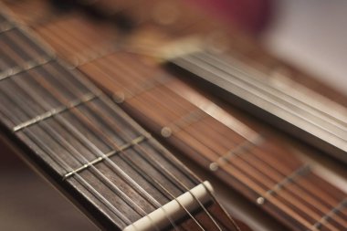 Gitar yansımalarının büyüleyici bir bileşimi sicimler, ahşap ve ışıktan oluşan karmaşık bir ağ yaratır..