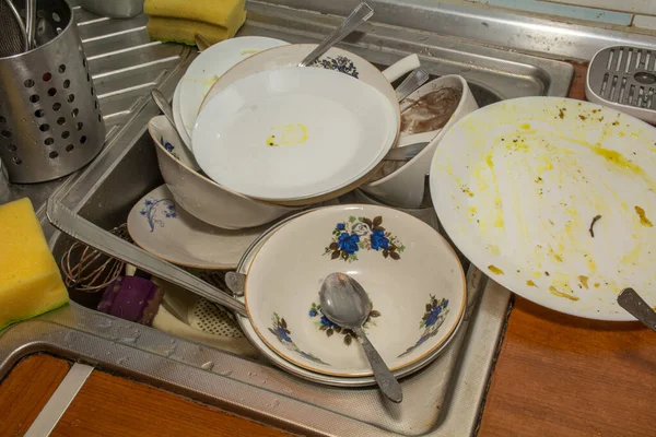 SINK FULL OF UNWASHED DISHES