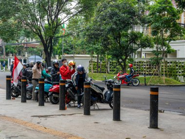 Jakarta, Indonesia - August 16, 2022: A motorcycle club ready for a touring with a flag during a commemoration of the Indonesian independence at a public park.