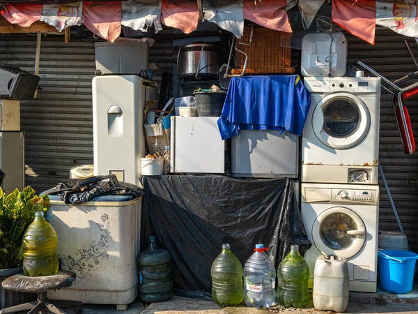 Jakarta, Indonesia - August 18, 2022: A pile of broken household appliances at the front of a repair shop on a bright sunny morning.