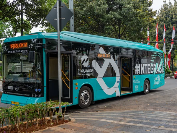 Jakarta, Indonesia - August 19, 2022: Front and side view of a teal blue electric city bus in Jakarta during morning service hours.